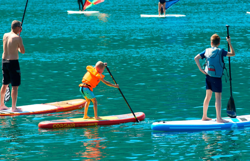 Paddler carrying a board toward the sheltered Anglet shoreline